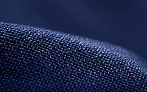 Cintas Corp. US1729081035 Makro-Detailaufnahme der Gewebetextur eines marineblauen Berufsuniforms unter präzisen Ringleuchten - Foto: THN