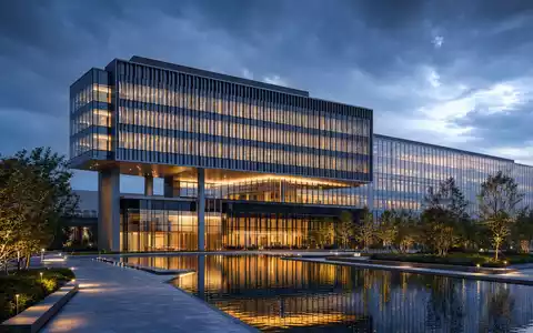 The Trade Desk (US88339J1051) zeigt Architektur-Render eines gläsernen Technologie-Hauptsitzes am Abend mit Teich - Foto: THN