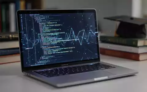 Nahaufnahme eines modernen silbernen Laptops mit leuchtendem Bildschirm, umgeben von verschwommenen Bildungsgegenständen, die Technologie und Bildung symbolisieren. - Foto: über boerse-global.de