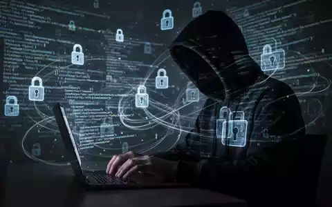 Verschattete Gestalt in dunklem Hoodie tippt auf Laptop, umgeben von digitalen Schlosssymbolen und Code. - Foto: über boerse-global.de