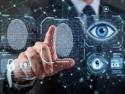 Eine menschliche Hand interagiert mit einer holografischen Schnittstelle, die biometrische Daten und digitale Zahlungssymbole zeigt, was eine sichere digitale Identitätsprüfung darstellt. - Foto: über boerse-global.de