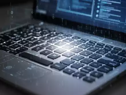 Nahaufnahme einer Laptop-Tastatur mit leuchtendem Bildschirm, die Windows 11-Einrichtung und Hardwareanforderungen darstellt. - Foto: über boerse-global.de