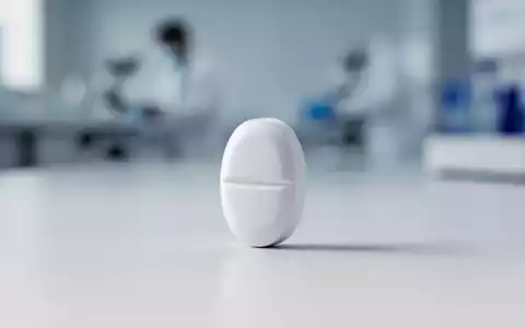 Eine einzelne weiße Pille auf einer sauberen, minimalistischen Oberfläche mit verschwommenem Hintergrund, der eine medizinische Umgebung andeutet. - Foto: über boerse-global.de