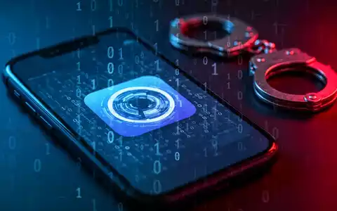 Nahaufnahme eines Smartphone-Bildschirms mit einem manipulierten App-Symbol und binärem Code, im Hintergrund Handschellen. - Foto: über boerse-global.de