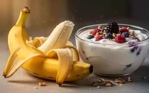Eine aufgeschnittene Banane liegt neben einer Schale Joghurt mit Beeren und Nüssen auf einer hellen Oberfläche. - Foto: über boerse-global.de