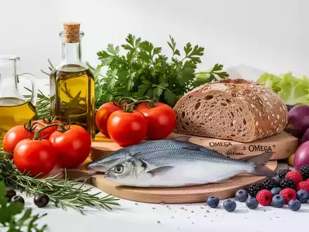 Eine appetitliche Anordnung mediterraner Lebensmittel, darunter Olivenöl, Tomaten, Fisch und frische Kräuter, auf einem hellen Tisch. - Foto: über boerse-global.de