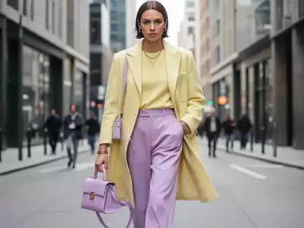 Eine stilvolle Person geht auf einer modernen Stadtstraße und trägt ein minimalistisches, luxuriöses Outfit mit Designer-Accessoires. - Foto: über boerse-global.de