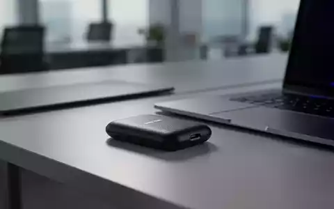 Schwarze SanDisk portable SSD auf modernem Schreibtisch neben Laptop, unscharfer Bürohintergrund. - Foto: über boerse-global.de