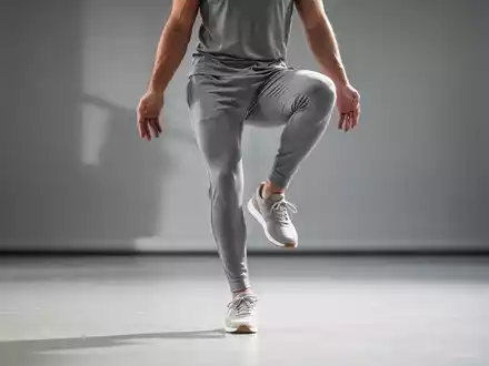 Eine Person in Sportkleidung führt eine Einbeinstand-Übung in einem minimalistischen Studio aus, um Gleichgewicht und Gesundheit zu symbolisieren. - Foto: über boerse-global.de