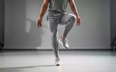 Eine Person in Sportkleidung führt eine Einbeinstand-Übung in einem minimalistischen Studio aus, um Gleichgewicht und Gesundheit zu symbolisieren. - Foto: über boerse-global.de