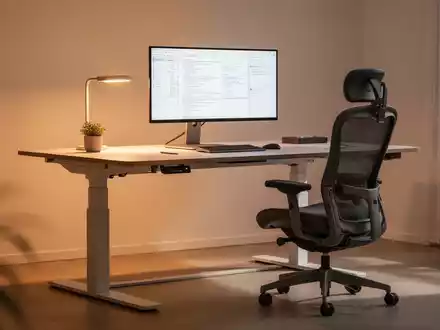 Ein modernes Homeoffice mit ergonomischem, höhenverstellbarem Schreibtisch, Stuhl und Monitor, unterstrichen von sanfter Beleuchtung. - Foto: über boerse-global.de