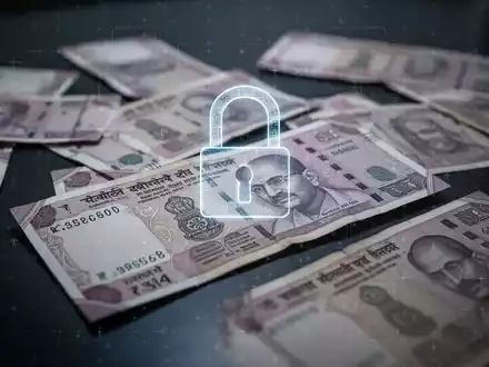 Verstreute indische Rupien-Scheine auf dunkler Fläche mit dezentem Vorhängeschloss-Symbol für digitale Verhaftungsbetrug und Finanzbetrug. - Foto: über boerse-global.de