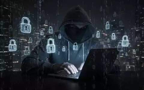 Verschwommene Gestalt in Kapuzenjacke tippt auf glühendem Laptop, umgeben von digitalem Code und Schloss-Symbolen, symbolisiert Datenlecks. - Foto: über boerse-global.de