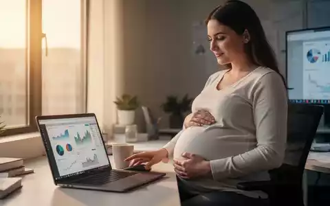 Eine schwangere Frau sitzt in einem modernen Büro und arbeitet am Laptop, während sie ihren Babybauch hält. - Foto: über boerse-global.de