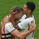 Jude Bellingham (r) lief nach seinem Tor zu Jordan Henderson. - Bild: Marta Lavandier/AP/dpa