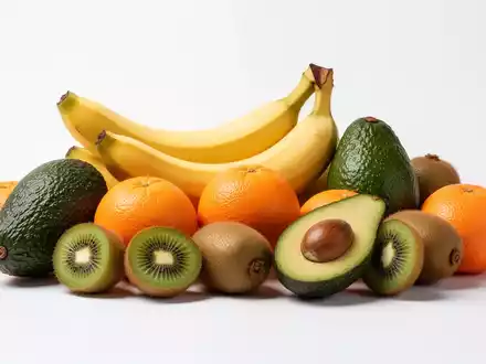 Eine Nahaufnahme einer bunten Auswahl an kaliumreichen Früchten wie Bananen, Avocados und Orangen, ästhetisch arrangiert. - Foto: über boerse-global.de
