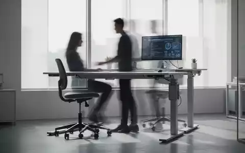 Ein moderner Arbeitsplatz mit höhenverstellbarem Schreibtisch und ergonomischem Rollhocker, der flexible Sitzmöglichkeiten symbolisiert. - Foto: über boerse-global.de
