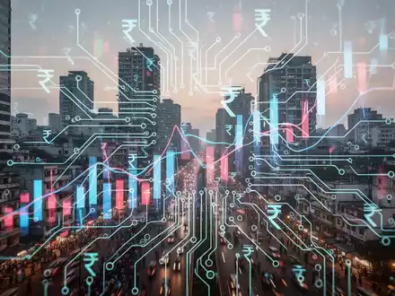 Futuristische Leiterplatte mit leuchtenden Linien, überlagert von abstrakten Finanzdiagrammen und indischen Rupien-Symbolen, vor moderner indischer Stadtkulisse. - Foto: über boerse-global.de