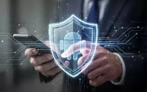 Ein stilisiertes, leuchtendes digitales Schildsymbol über einem unscharfen Hintergrund, der eine Person bei der Nutzung eines Android-Smartphones zeigt. - Foto: über boerse-global.de