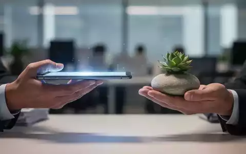 Hände balancieren ein leuchtendes digitales Gerät und einen glatten Flussstein, symbolisierend Work-Life-Balance und digitale Entlastung. - Foto: über boerse-global.de