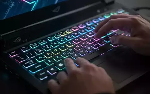 Nahaufnahme von Händen auf einer Gaming-Laptop-Tastatur mit bunter RGB-Beleuchtung, die leistungsstarke Hardware betont. - Foto: über boerse-global.de