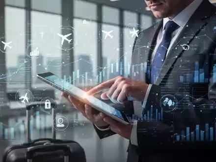 Ein Geschäftsreisender prüft auf einem Tablet digitale Reisekostenabrechnungen vor einem Hintergrund mit Finanzdaten und Reisesymbolen. - Foto: über boerse-global.de