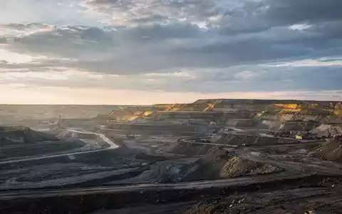 Eine weite, abstrakte Bergbaulandschaft unter dramatischem Himmel, die Vorfreude und Marktpotenzial vermittelt. Weiches, warmes Licht am Horizont deutet zukünftiges Wachstum an. - Foto: über boerse-global.de