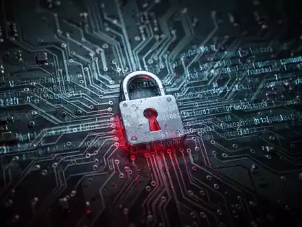 Leuchtende Platine mit digitalem Code-Overlay, dezentem Vorhängeschloss-Symbol und bedrohlicher rot-blauer Beleuchtung, symbolisiert Cybersicherheits-Schwachstelle. - Foto: über boerse-global.de