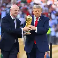Donald Trump (r) und Gianni Infantino bringen den WM-Pokal. - Foto: Tom Weller/dpa
