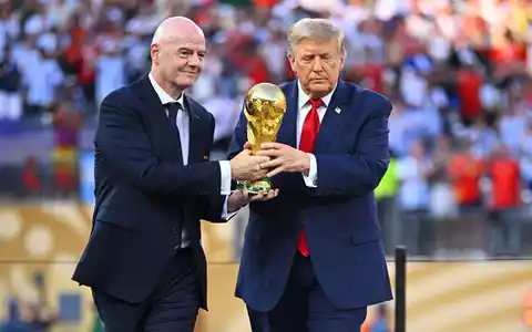Donald Trump (r) und Gianni Infantino bringen den WM-Pokal. - Foto: Tom Weller/dpa