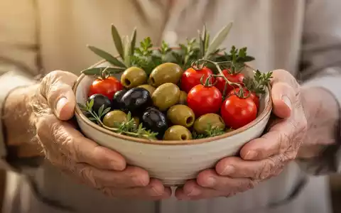 Ältere Hände halten eine Schale mit frischen mediterranen Zutaten, symbolisierend gesunde Ernährung und Demenzprävention. - Foto: über boerse-global.de