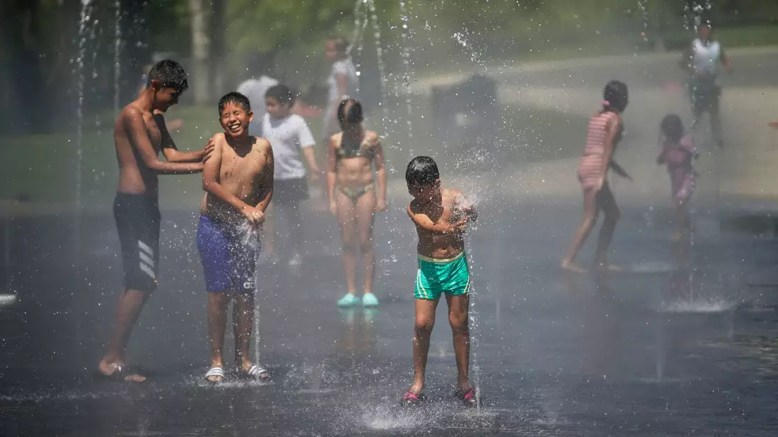 Kinder suchen Abkühlung in der spanischen Hauptstadt Madrid. (Archivbild) - Bild: Andrea Comas/AP/dpa