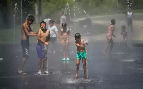 Kinder suchen Abkühlung in der spanischen Hauptstadt Madrid. (Archivbild) - Foto: Andrea Comas/AP/dpa