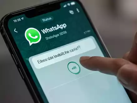 Nahaufnahme eines Smartphone-Bildschirms mit WhatsApp-Status, dessen Bildunterschrift bearbeitet wird, als Symbol für neue Funktionen. - Foto: über boerse-global.de