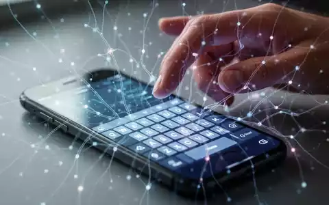 Ein Smartphone mit virtueller Tastatur, abstrakten KI-Linien und einer darüber gestikulierenden Hand, die neue Barrierefreiheitsfunktionen darstellt. - Foto: über boerse-global.de