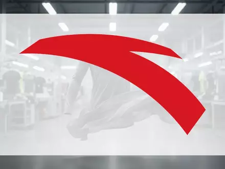 Abstrakte Darstellung einer modernen Sportbekleidungsfabrik mit fließendem Stoff im Vordergrund, symbolisierend Wachstum und Effizienz. - Foto: über boerse-global.de