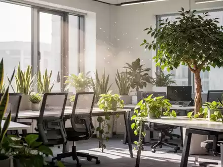 Ein modernes, minimalistisches Büro mit grünen Zimmerpflanzen wie Sansevieria und Efeutute, die das Raumklima verbessern. - Foto: über boerse-global.de
