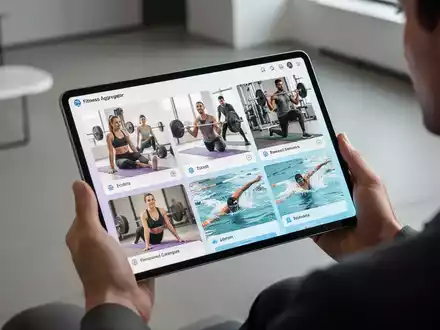 Eine Person hält ein Tablet, auf dem verschiedene Fitnessaktivitäten als Teil einer Aggregator-App dargestellt sind, im Vordergrund ein Fitnessstudio. - Foto: über boerse-global.de