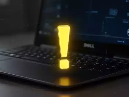 Gelbes Ausrufezeichen-Symbol auf dunklem Bildschirm, verschwommene Dell-Tastatur im Hintergrund. - Foto: über boerse-global.de