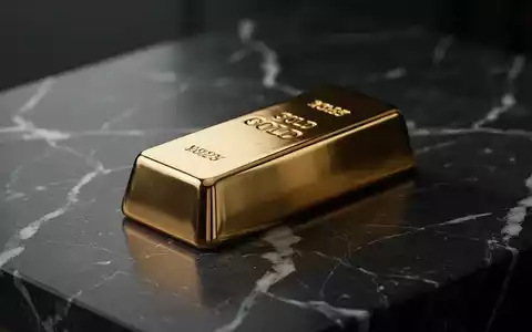 Ein glänzender Goldbarren auf einer dunklen Marmoroberfläche mit weicher, kinoreifer Beleuchtung. - Foto: über boerse-global.de