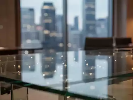 Ein moderner, professioneller Schreibtisch in einem Finanzbüro mit verschwommener Stadtkulisse im Hintergrund. - Foto: über boerse-global.de