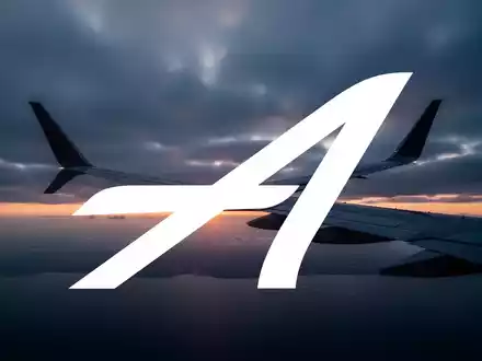 Flügel eines modernen Passagierflugzeugs vor einem wolkenverhangenen Himmel bei Sonnenaufgang. - Foto: über boerse-global.de