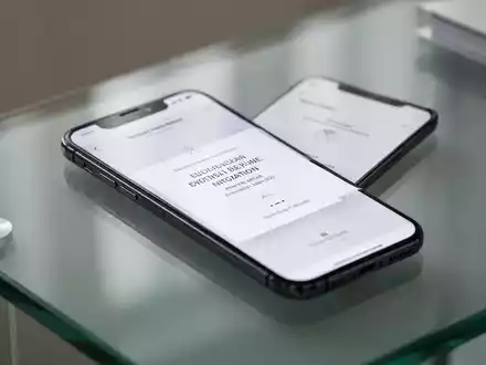 Ein Smartphone zeigt eine digitale Event-Einladungsoberfläche auf einem modernen Schreibtisch. - Foto: über boerse-global.de