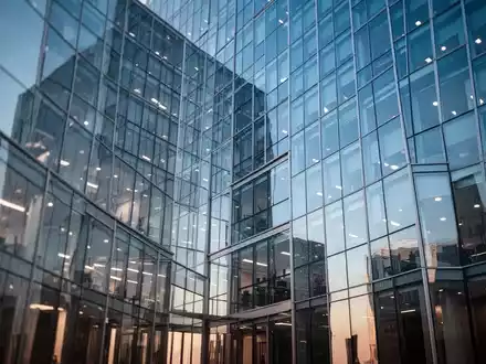 Moderne Glasfassade eines Bürogebäudes bei klarem Himmel als Symbol für Finanzmärkte und Aktieninvestitionen. - Foto: über boerse-global.de