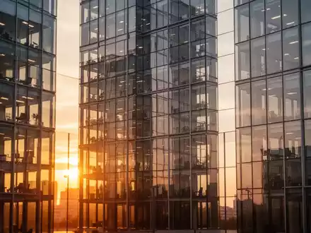 Moderne Glasfassade eines Bürogebäudes bei Sonnenuntergang als Symbol für den Immobilienmarkt. - Foto: über boerse-global.de