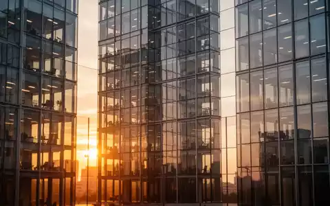 Moderne Glasfassade eines Bürogebäudes bei Sonnenuntergang als Symbol für den Immobilienmarkt. - Foto: über boerse-global.de