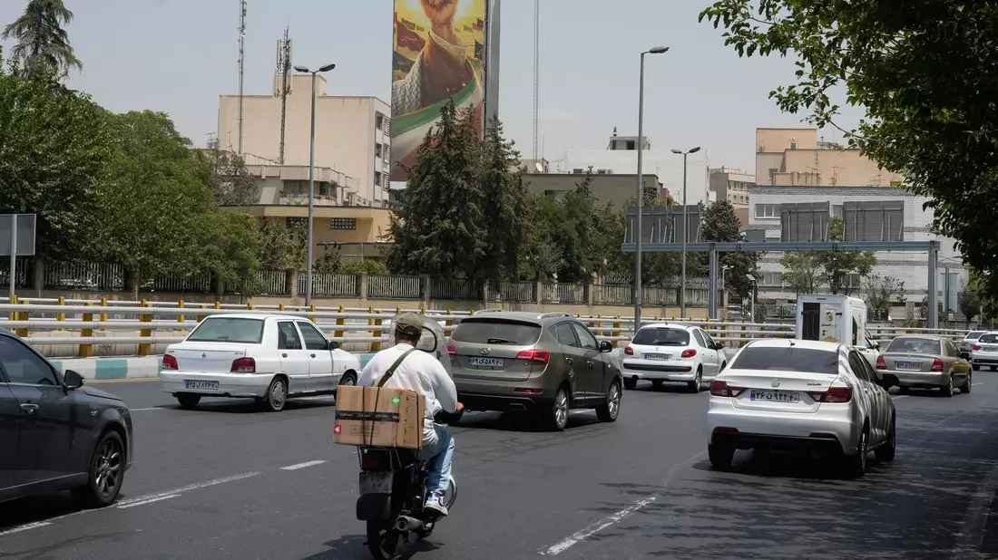 Fahrzeuge fahren in Teheran an einer Plakatwand vorbei, auf der die geballte Faust des verstorbenen iranischen Obersten Führers Ajatollah Ali Chamenei zu sehen ist. (Archivbild) - Bild: Vahid Salemi/AP/dpa