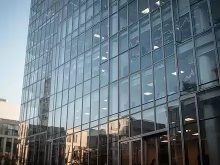 Modernes Bürogebäude vor blauem Himmel, das globale Finanzmärkte und die Index-Überprüfung symbolisiert. - Foto: über boerse-global.de