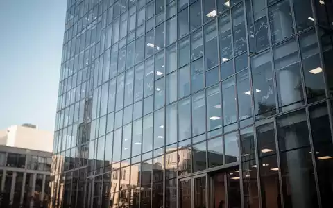 Modernes Bürogebäude vor blauem Himmel, das globale Finanzmärkte und die Index-Überprüfung symbolisiert. - Foto: über boerse-global.de