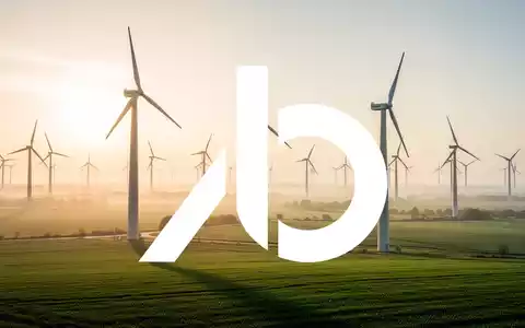 Moderne Windkraftanlagen in einer sonnigen grünen Landschaft bei Sonnenaufgang. - Foto: über boerse-global.de